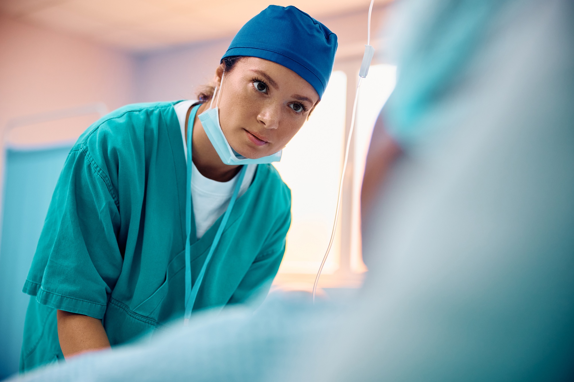 Mid adult nurse taking care of a patient at intensive care unit.
